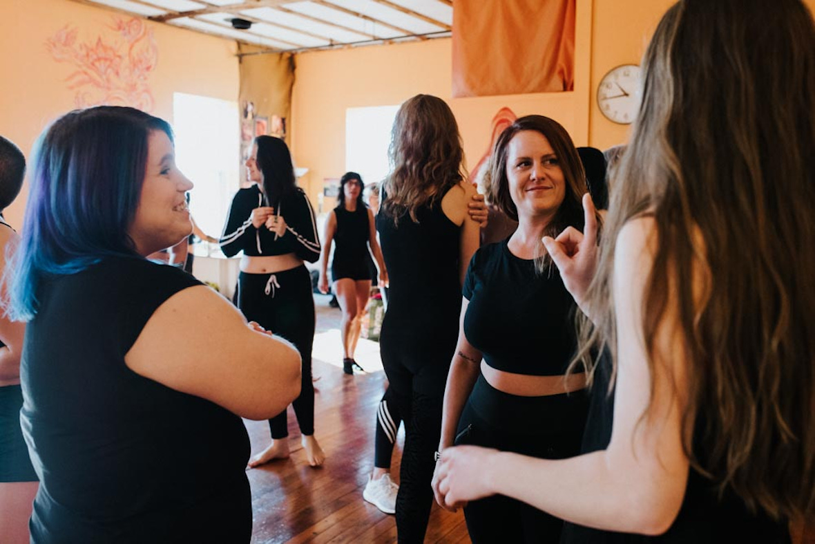 A group of women have a lively conversation during a class break at Hustle and Flow