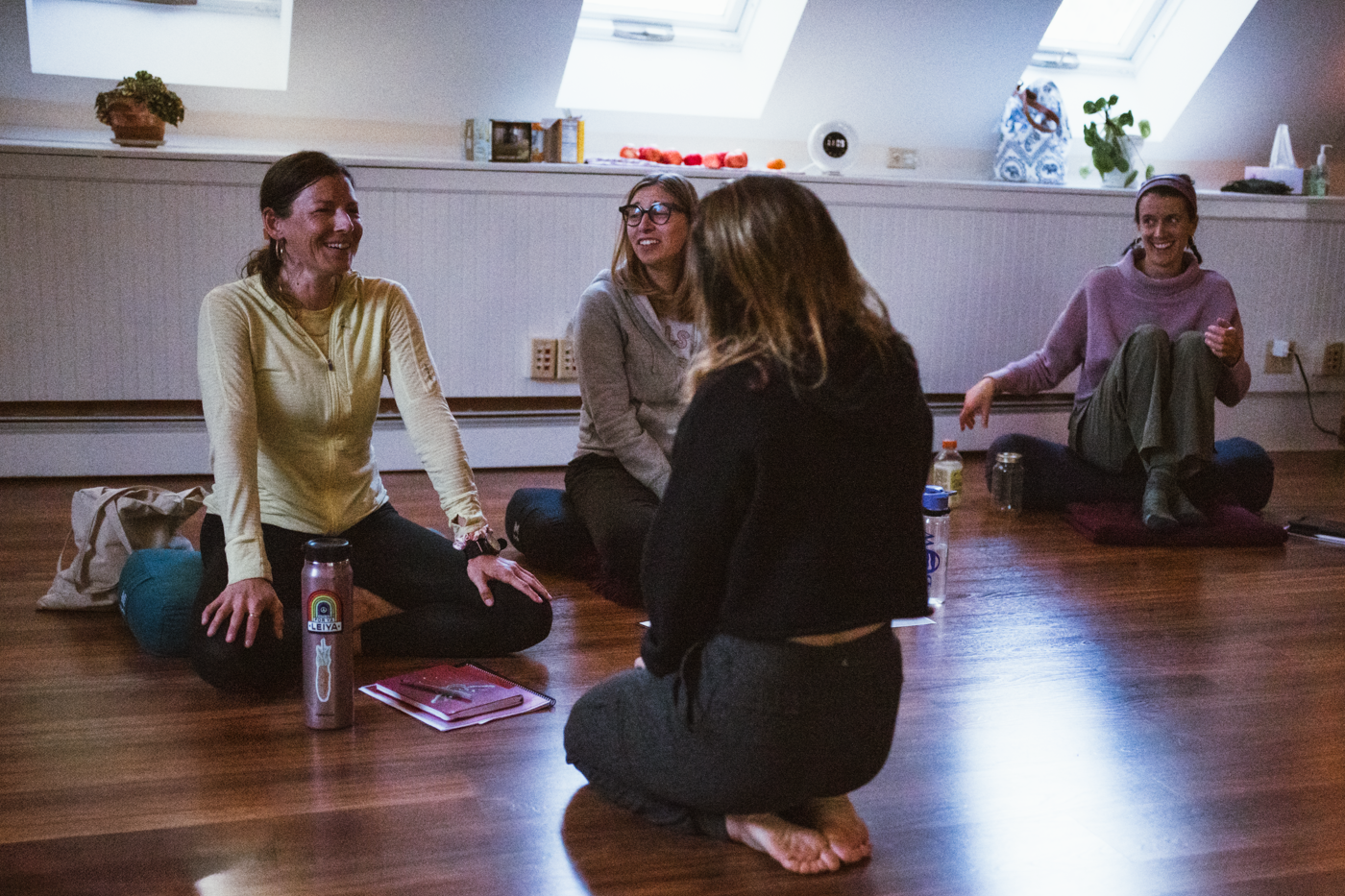 A woman in a sparkly black sports bra raising her right arm above her head while looking upward.