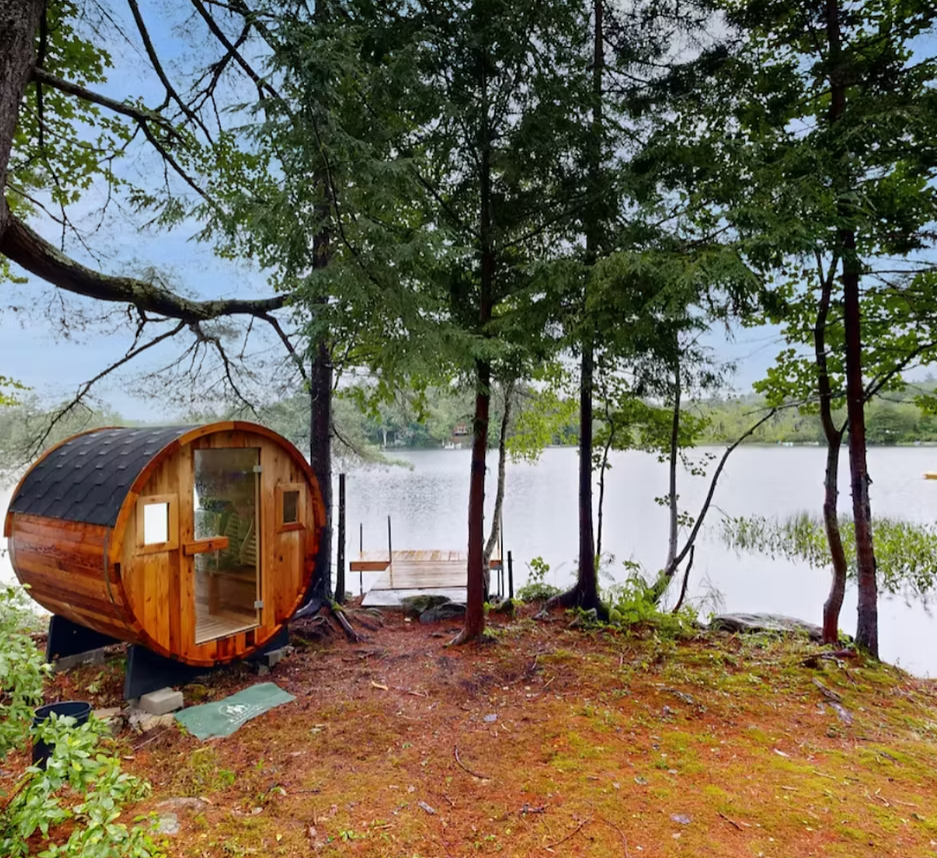 A woman in a sparkly black sports bra raising her right arm above her head while looking upward.